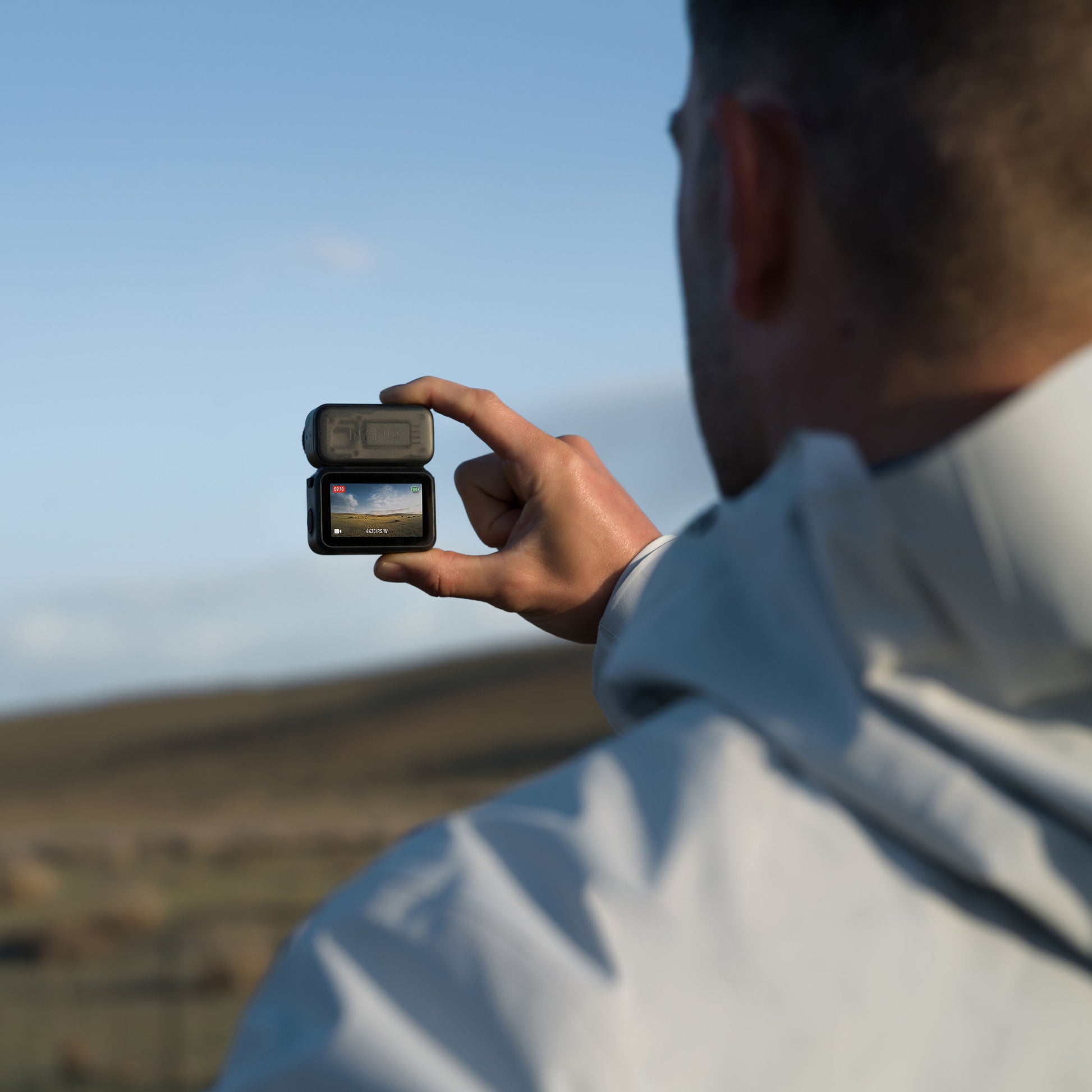 DJI Osmo Nano actionkamera 128GB med magnetisk fastgørelse, 4K-skærm viser optagelse, personhånd delvist synlig.
