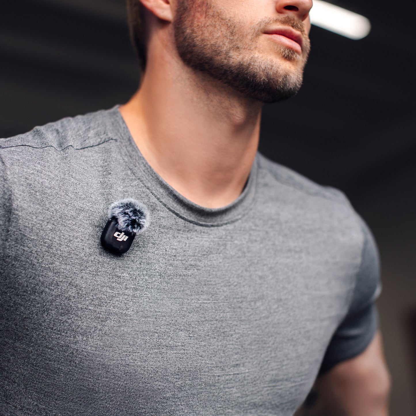 DJI Mic 3 trådløst mikrofonsystem 1 TX+1 RX med vindhætte klipset på grå t-shirt.