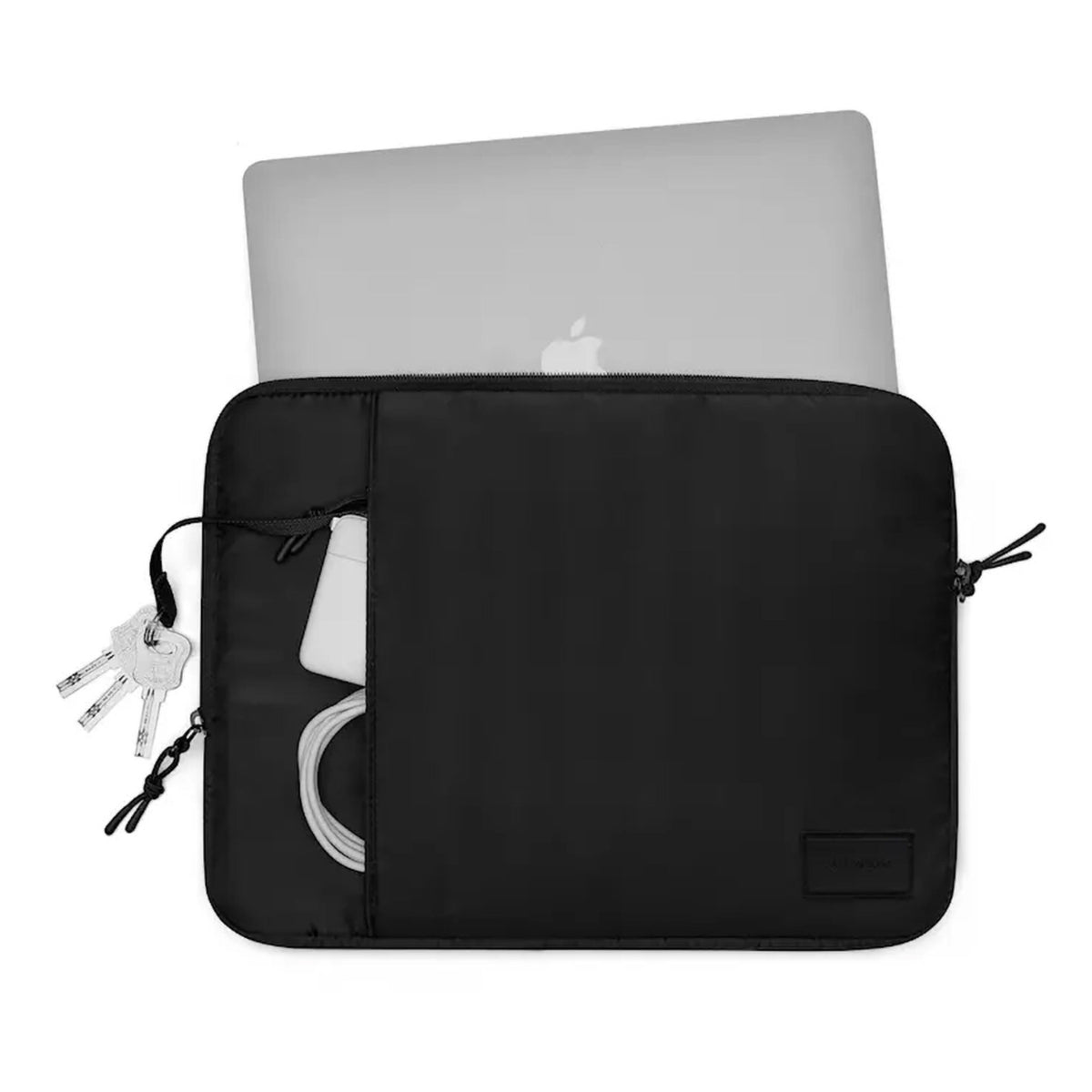 Apple MacBook i Gaston Luga Däsh polstret taske 13/14″, sort, synligt Apple-logo, opladerkabel, strømadapter og nøgler i forlommen.