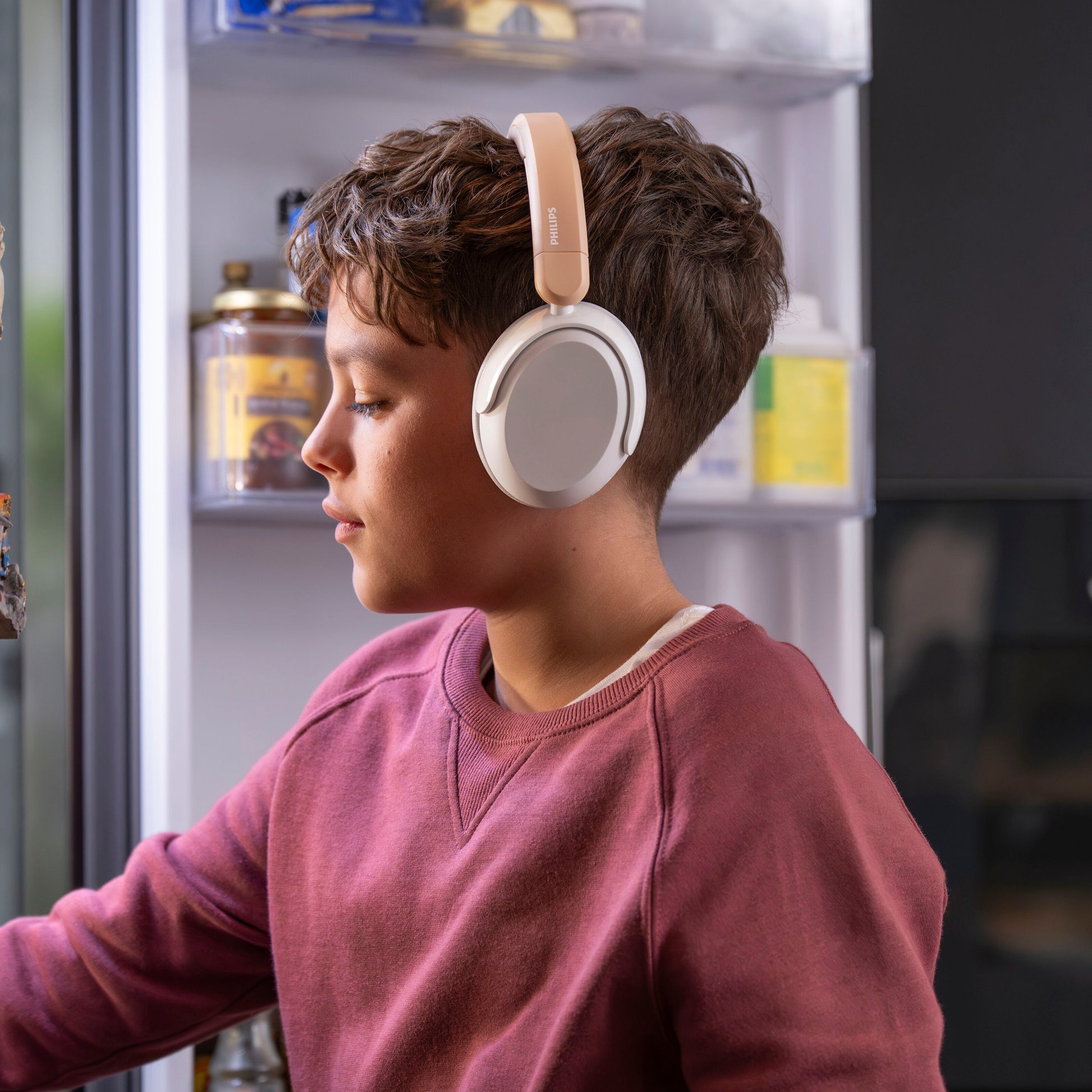 Philips trådløse over-ear hovedtelefoner til børn med støjreduktion, beige, bæres af dreng.