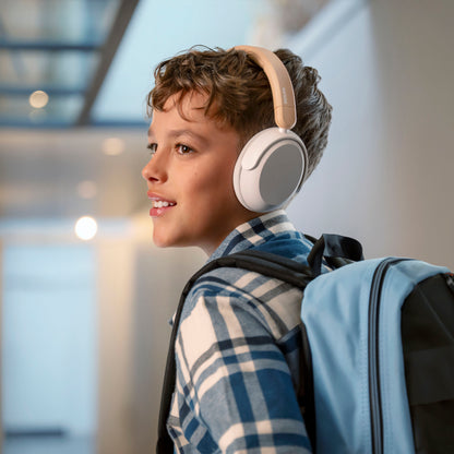 Philips beige trådløse over-ear hovedtelefoner til børn med støjreduktion bæres af dreng iført blåternet skjorte.