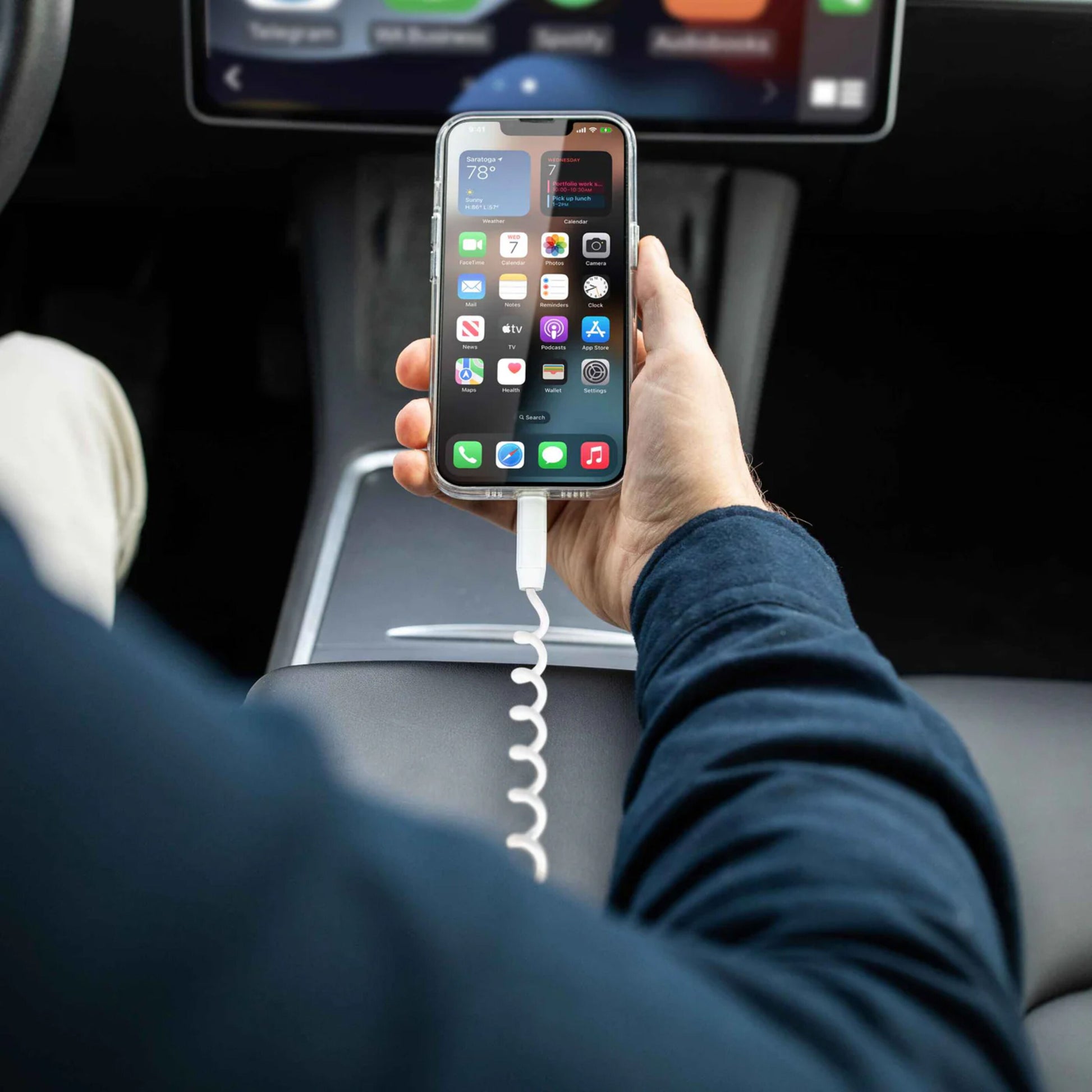 IPhone tilsluttet Vonmählen Allroundo Eco 6-i-1 opladerkabel Hvid vises i bil med hjemmeskærm og instrumentbræt.