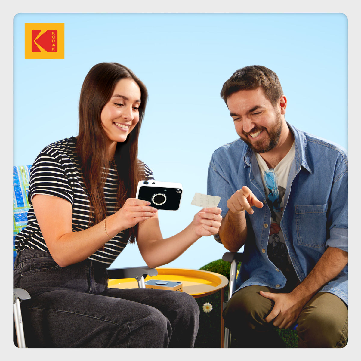 Kodak Printomatic+ 10 MP øjeblikskamera med ZINK-udskrivning og udskrevet foto.