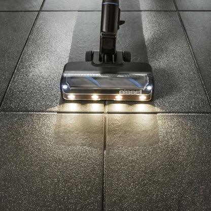 Bissel PowerClean FurFinder Select skaftstøvsuger med LED-hoved på mørkegråt, let tekstureret klinkegulv.