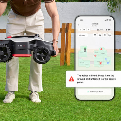 Dreame A3 AWD 1000 robotplæneklipper løftes, Dreame app på smartphone viser status og advarsel om at robotten er løftet.
