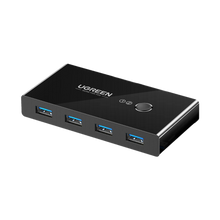 Sort Ugreen USB 3.0-switch, 4 porte til to computere, 5 Gbps, med rund trykknap til at skifte mellem computere.