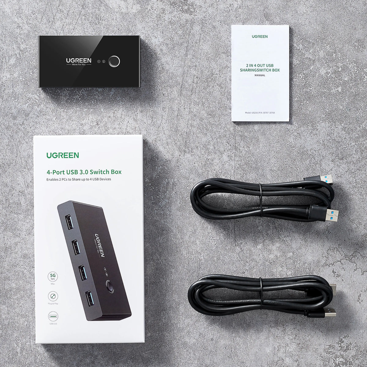Ugreen USB 3.0-switch med 4 porte til 2 computere, 5 Gbps, inkl. 2 USB-kabler, brugervejledning og emballage.