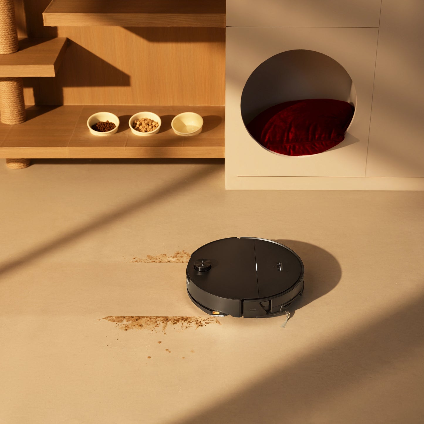 Roborock Saros 20 Sonic sort robotstøvsuger med vibrerende moppe på beige gulv nær pet-område med skåle og rød hundeseng.