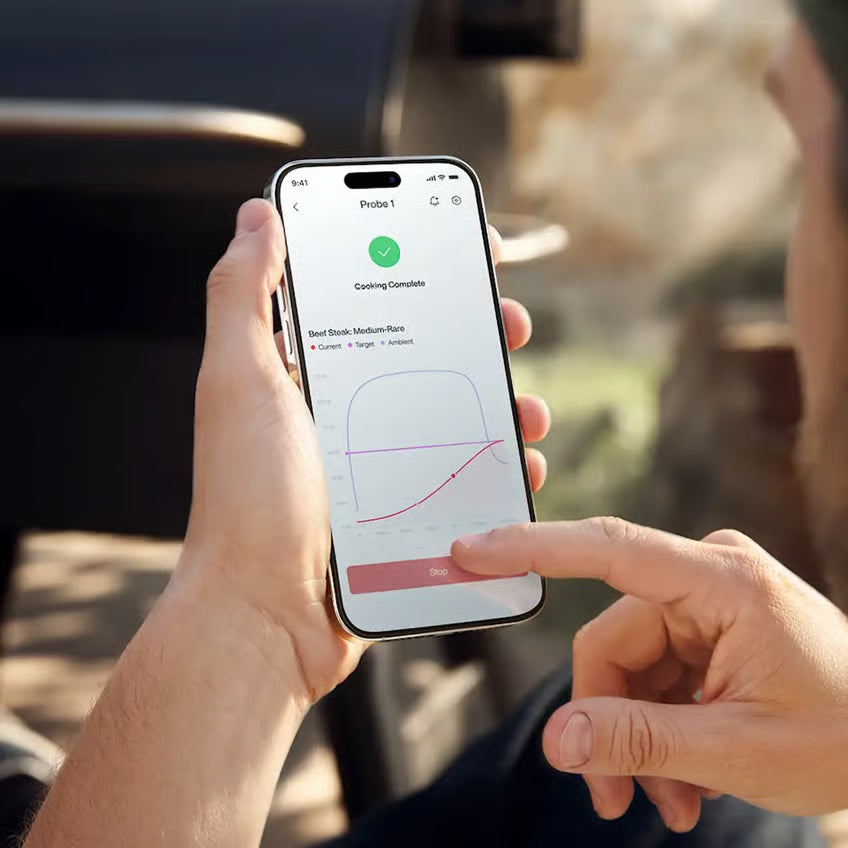 Typhur Sync Dual – trådløst grill- og stegetermometer til smartphone, to sondespidser, temperaturkurve og visning af »Cooking Complete«.