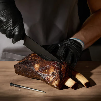TYPHUR Sync Dual – trådløst grill- og stegetermometer med to sonder ved siden af et udskåret okseribben på et træbord.