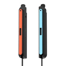 Et sæt Joy-Con-kontroller til Nintendo Switch, hvoraf den ene har en rød rem og den anden en blå, samt en sort Joy-Con-adapter til Nintendo Switch 2.
