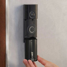 Ring Quick Release Ultra-batteripakke – sort, genopladeligt lithium-ion-batteri, der sættes i et sort dørklokkekamera på en lys væg.