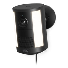Ring Spotlight Cam Plug-in Retinal 2K-model, vægmonteret, vippet mod højre med synlig strømkabel nederst.