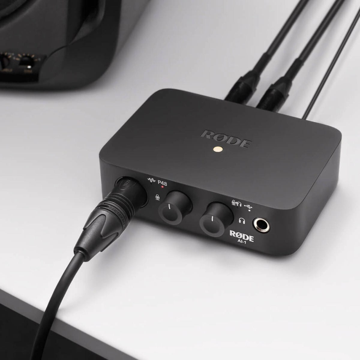 RØDE AI-1 sort USB-lydinterface med to knapper, hovedtelefonudgang og flere tilsluttede kabler.