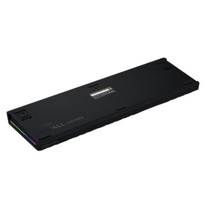 HATOR Skyfall 100 Pro trådløst gaming-tastatur, sort, set bagfra med to justerbare fødder, teknisk mærkat og RGB-lysbånd langs venstre kant.
