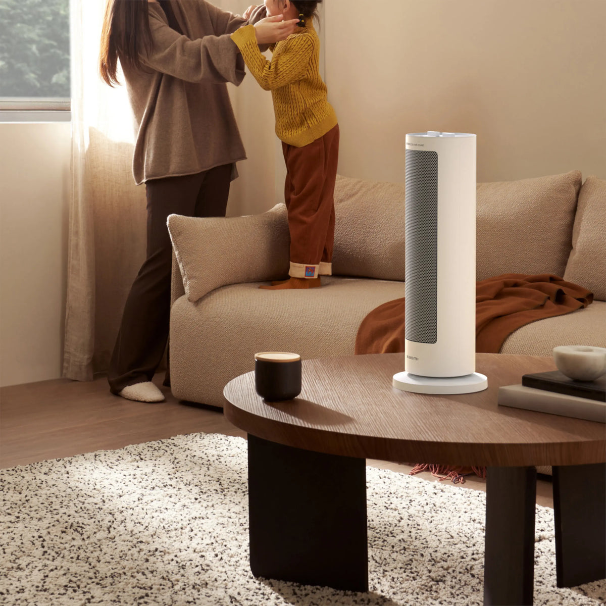 Xiaomi-varmeblæseren (EU-model med PTC-varmeelement) på 2000 W, hvid, står fremme i stuen foran sofaen og sofabordet.