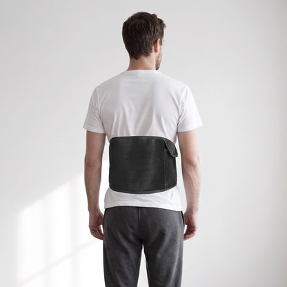 Et elektrisk varmebælte til mave og ryg med USB-C-stik, placeret omkring lænden uden på en hvid T-shirt.