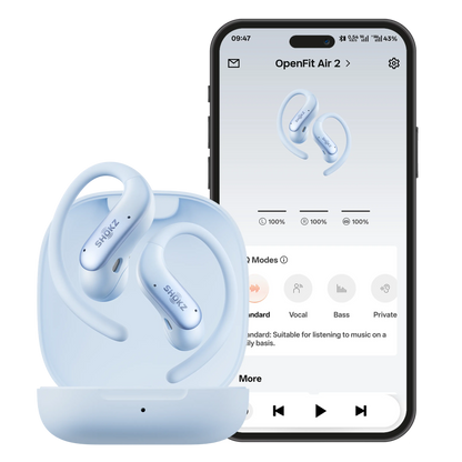Shokz OpenFit Air 2 open-ear-høretelefoner i blå farve i opladningsetuiet ved siden af en smartphone med Shokz-appen og lydindstillinger.