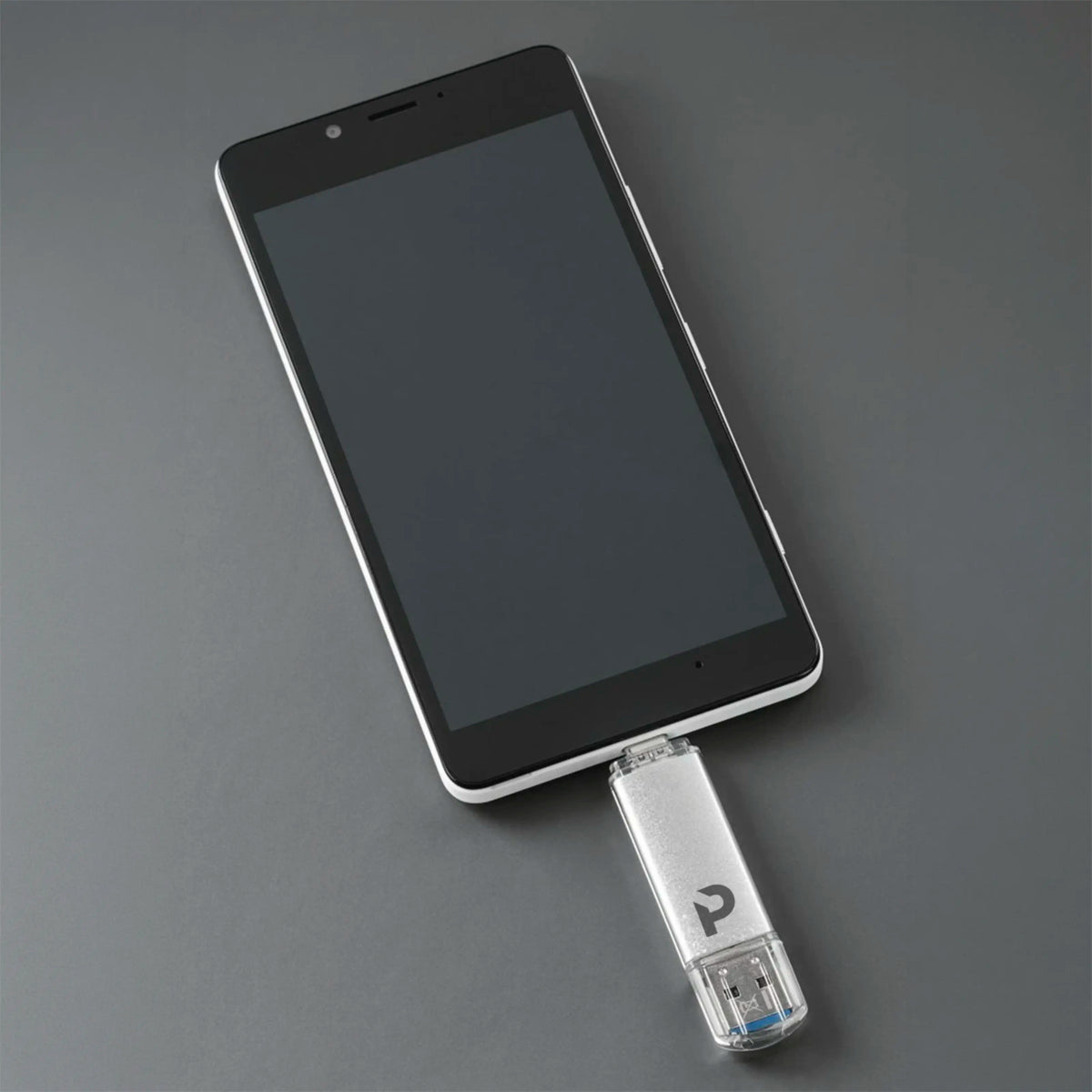 Plexgear 32 GB USB-nøgle med USB-C og USB-A tilsluttet en smartphone.