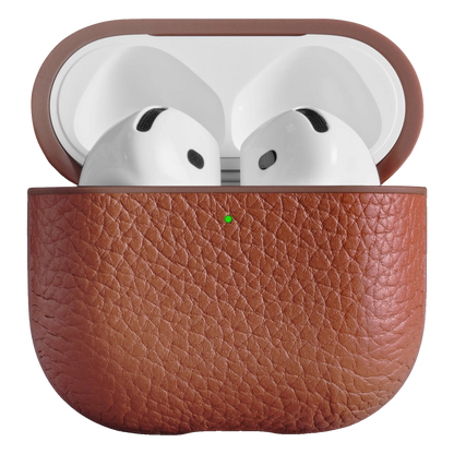 Woolnut læderetui til AirPods 5 i cognacfarve, åbent etui med hvide trådløse øretelefoner og grøn opladningslampe.