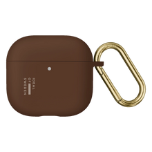 Brunt silikoneetui til AirPods Gen 4/5 i farven Mocha Mousse med guldfarvet metalkarabinhage.