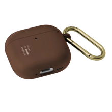 IDeal of Sweden silikoneetui i farven Mocha Mousse til AirPods Gen 4/5 med guldfarvet metal-karabinhage.