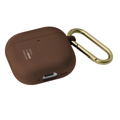 IDeal of Sweden silikoneetui i farven Mocha Mousse til AirPods Gen 4/5 med guldfarvet metal-karabinhage.