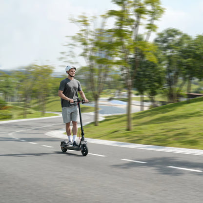 Mand med hvid hjelm på en Xiaomi Electric Scooter Elite NE el-løbehjul på en sti.