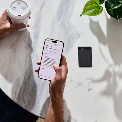 Smartphone med AI-diktafon-app og sort PLAUD Note Pro AI-diktafon til mødeoptagelse og transskription.