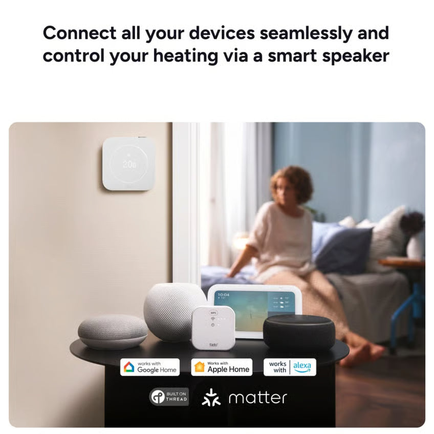 Tado° trådløs temperaturføler, 2. generation – trådløs temperaturføler monteret på væggen over bordet sammen med smart-enheder.