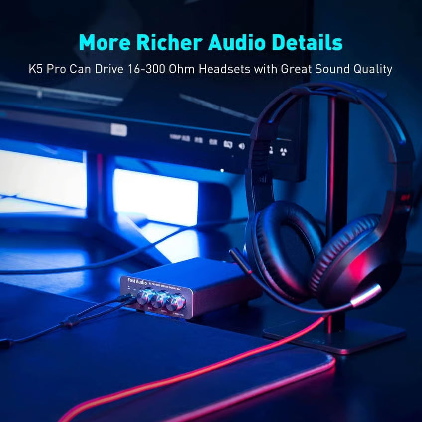 Fosi Audio K5 Pro gaming-DAC og hovedtelefonforstærker med tre knapper på forsiden, tilsluttet et headset på en stativ.