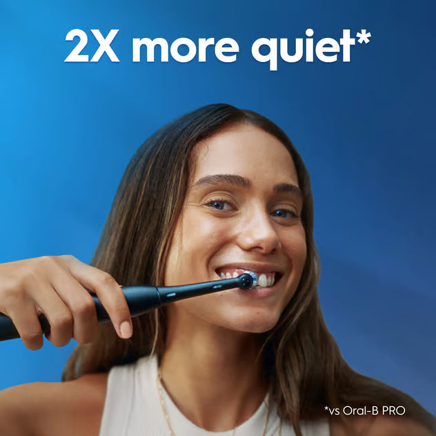 Kvinde børster tænder med Oral-B iO Series 2 Night Black elektrisk tandbørste med tryksensor og rejseetui samt 2X more quiet-tekst.