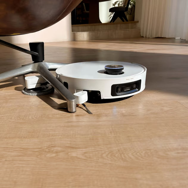 Hvid Dreame X60 Pro Ultra – komplet robotstøvsuger med moppe og ProLeap-system på trægulvet under stolen.