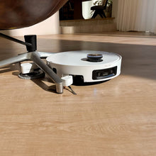 Hvid Dreame X60 Pro Ultra – komplet robotstøvsuger med moppe og ProLeap-system på trægulvet under stolen.