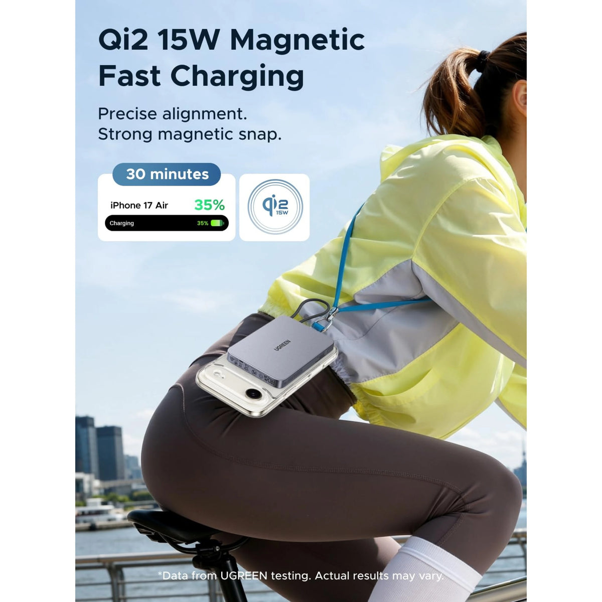Grå Ugreen MagFlow Air MagSafe-powerbank på 10.000 mAh monteret på bagsiden af telefonen under en cykeltur.
