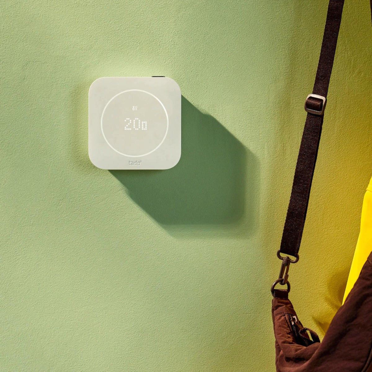 Tado° kablet smart termostat X, 2. generation, startpakke med Bridge X monteret på væggen, viser temperatur og varmeikon.