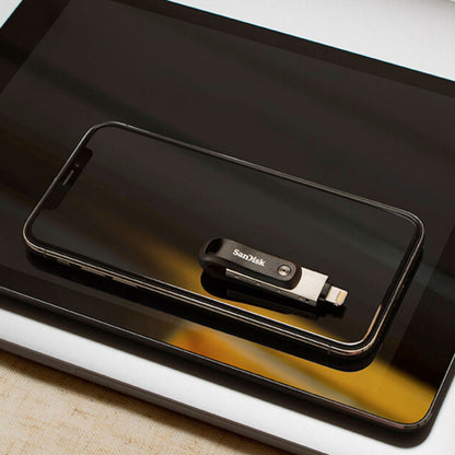 Sandisk iXpand Go USB-nøgle 256GB med Lightning-stik på sort smartphone, begge ovn på tablet.