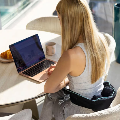Medivon Motion X trådløs Shiatsu-nakkemassage i sort, brugt sammen med en bærbar computer ved et bord.