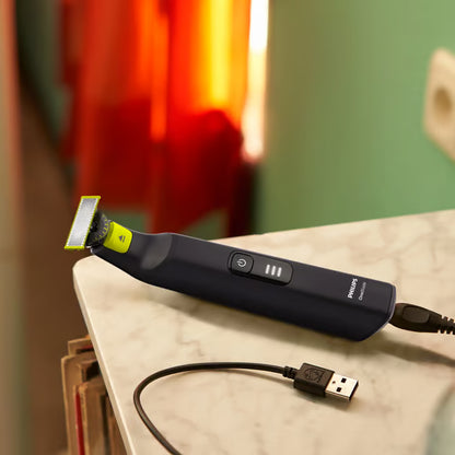 Philips OneBlade Pro 360 QP6542/15 ansigts- og kropstrimmer i sort og limegrøn med justerbart blad og USB-opladerkabel.