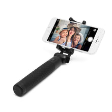 Linocell selfiestang med Bluetooth-udløser holder smartphone, skærm viser tre børn i sommerhatte.
