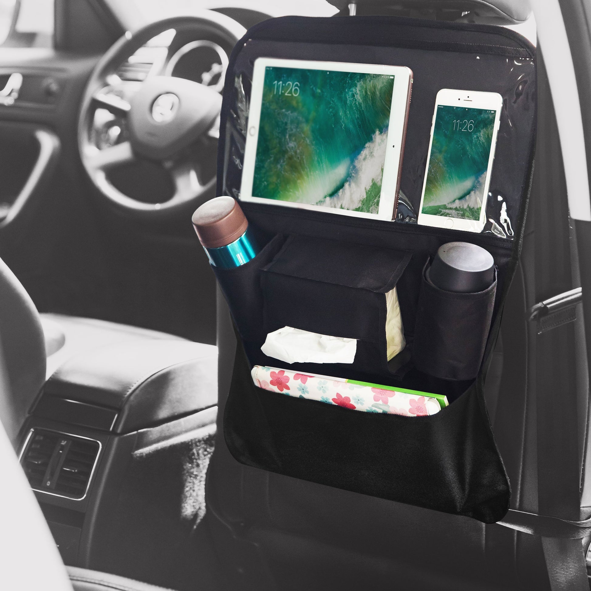 Linocell Praktisk holder til tablet og gadgets fra Linocell er en sort bilsæde-organizer med opbevaringslomme og sparkebeskyttelse, der har en tabletholder, flaskepladser, lommetørklædeåbninger og meget mere, så du kan holde din bil pæn og organiseret.