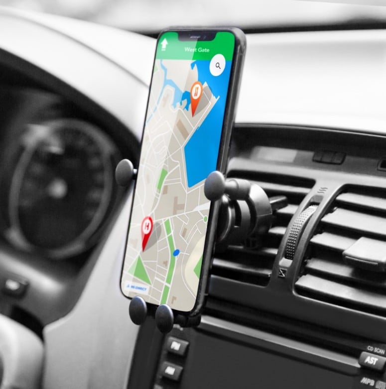 Linocell Mobilholder med quick release til ventilatorgitter monteret i bil med smartphone og rat synligt.