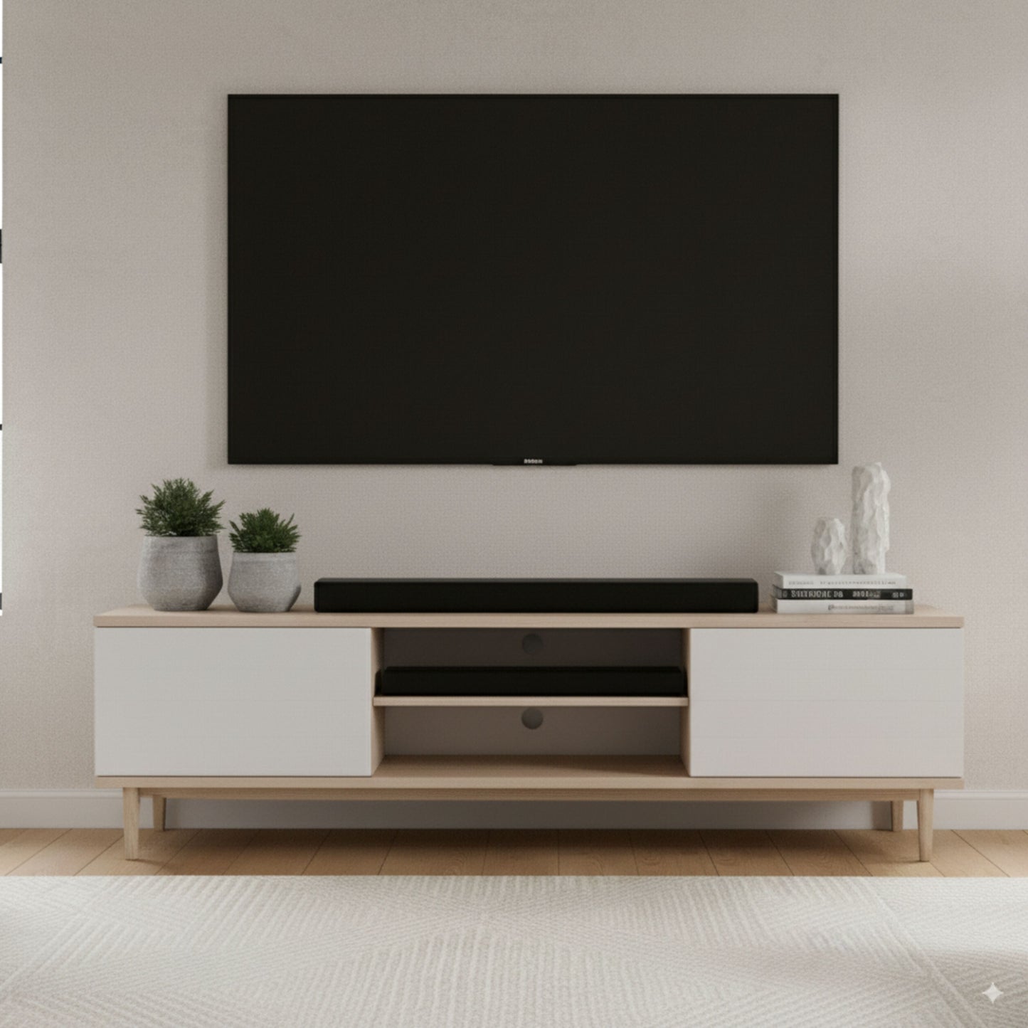 Nomadelic 2.1 Soundbar Loud 750 sort under vægmonteret fladskærm på træ tv-bord med hvide låger.
